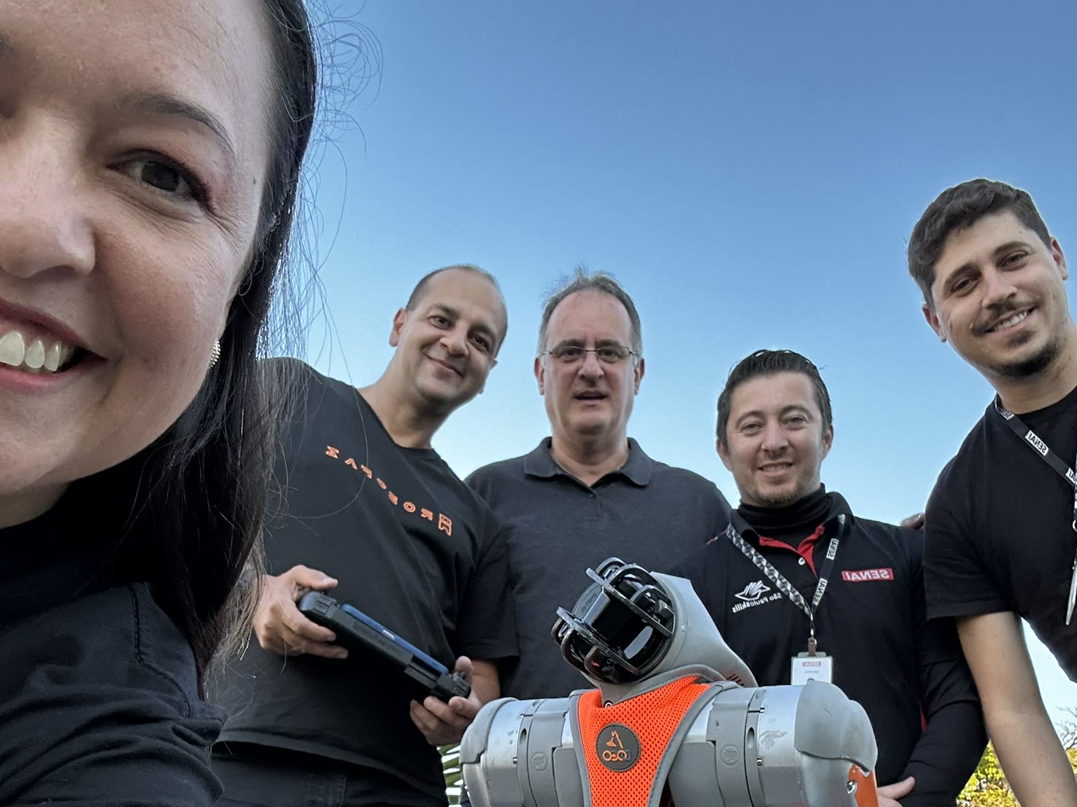 Equipe da RoboFaz com o cão robô durante um evento em escola parceira